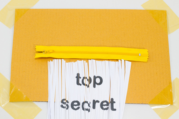 Top Secret, distruggendo foglio di carta con cerniera gialla come trituratore
. - Foto, immagini
