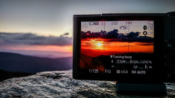 山中カメラで夕日の写真を撮る - 写真・画像
