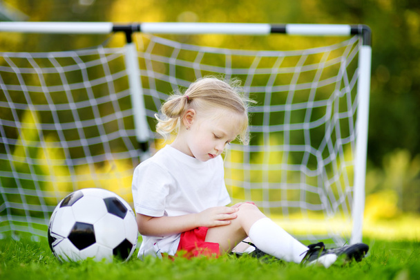 Cute little soccer player hurt her knee - Valokuva, kuva