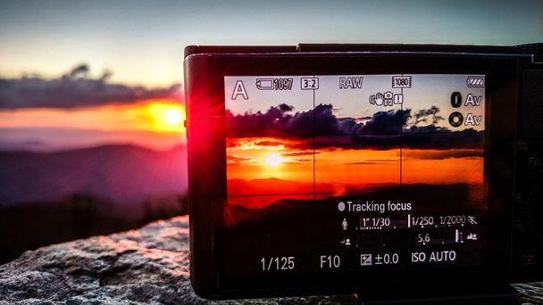 λαμβάνοντας sunset photo με μια φωτογραφική μηχανή στα βουνά - Φωτογραφία, εικόνα