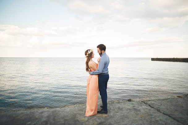 Beautiful loving couple, pride with long dress walking on pier - Foto, Imagem
