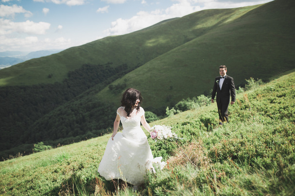 Beautiful gorgeous bride posing to groom and having fun, luxury ceremony at mountains with amazing view, space for text, wedding couple - 写真・画像