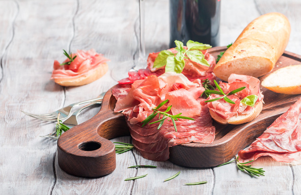 Concept of italian food with red wine, melon and prosciutto - Photo, image