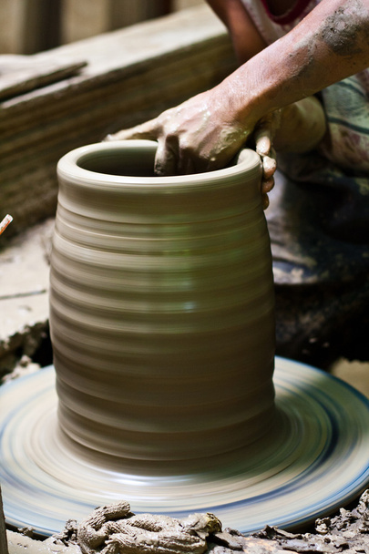Potter's wheel and hands of craftsman hold a jug. - Zdjęcie, obraz