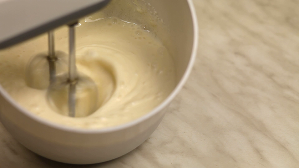 Mixing cream with mixer in the bowl - Кадри, відео