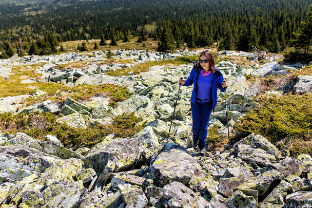 Nainen vaeltaa vuorilla kivien ja kivien seassa. Polku korkealle huipulle
 - Valokuva, kuva