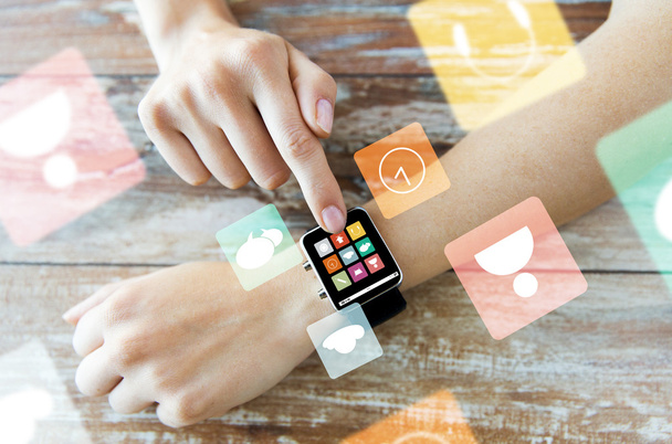 close up of hands setting smart watch with icons - Foto, Bild