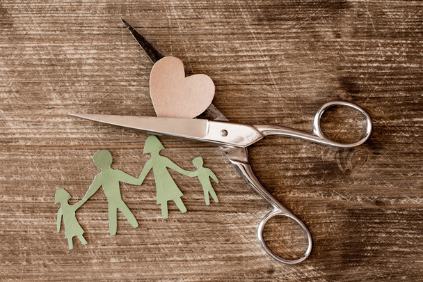 Scissors with cutout paper family and heart  - Photo, Image