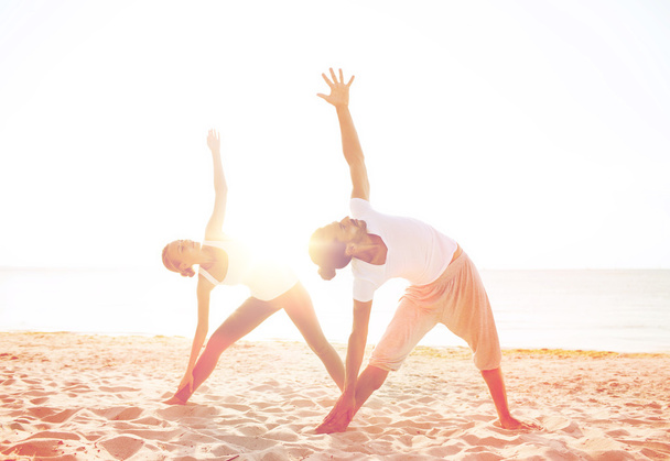 couple making yoga exercises outdoors - Foto, afbeelding