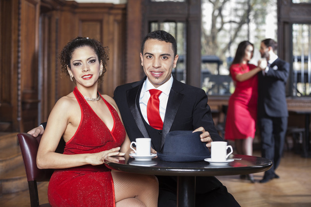 Confident Young Couple Sitting At Table While Tango Partners Dan - 写真・画像