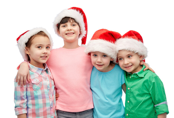 happy little children in santa hats hugging - Photo, image