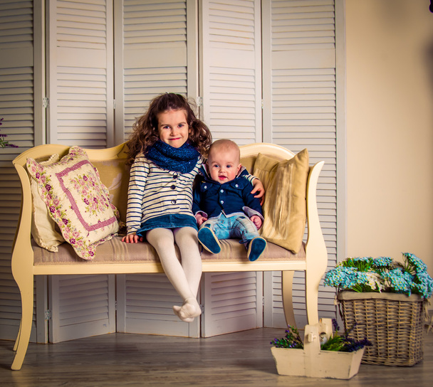 hermano con hermana en un hermoso sofá cojines
 - Foto, Imagen
