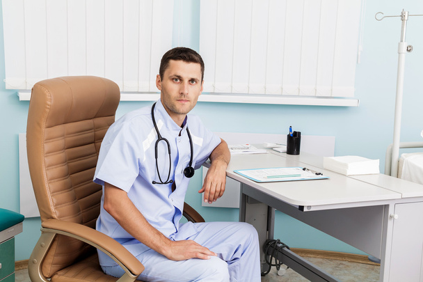 Porträt eines jungen Arztes in seiner Arztpraxis. der Arbeitsplatz des Arztes in der Klinik - Foto, Bild