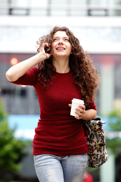 Mujer caminando y hablando por teléfono
 - Foto, imagen