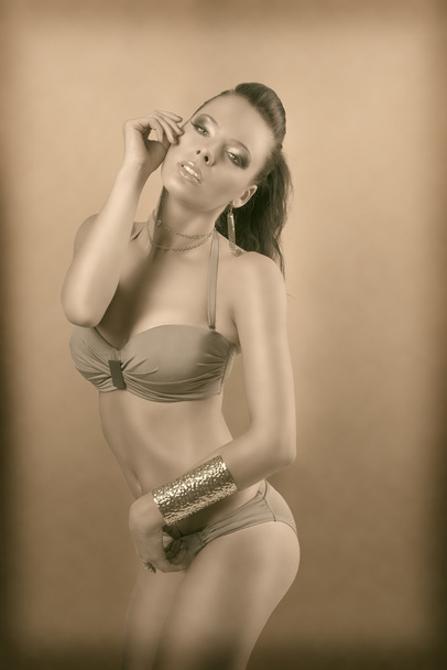Vintage color sexy brunette in bikini with hand near the face - Foto, Imagem