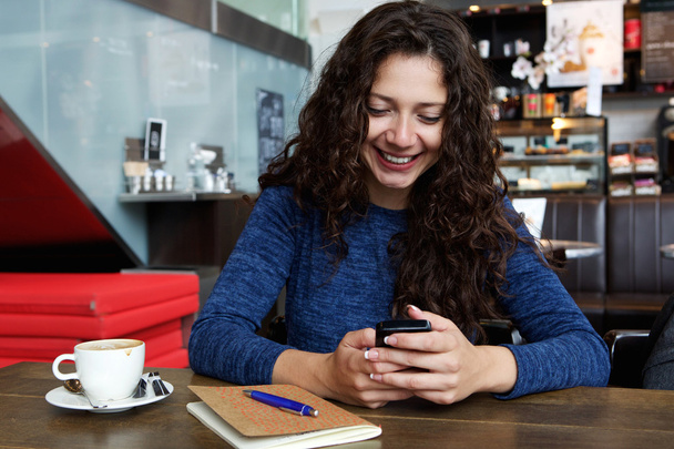 Kobieta siedzi w kawiarni z telefonu komórkowego - Zdjęcie, obraz