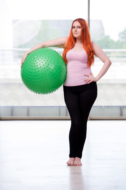 Jonge vrouw trainen met de swiss ball in gezondheid concept - Foto, afbeelding