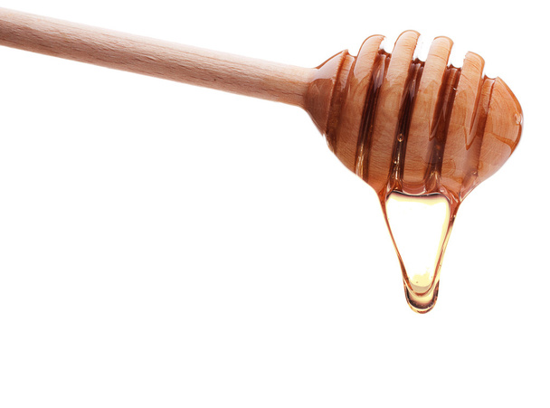 Honey dripping from a honey dipper - Φωτογραφία, εικόνα