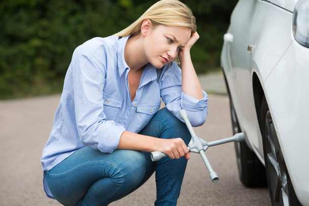 Frustrated Female Driver With Tire Iron Trying To Change Wheel - Foto, Imagem