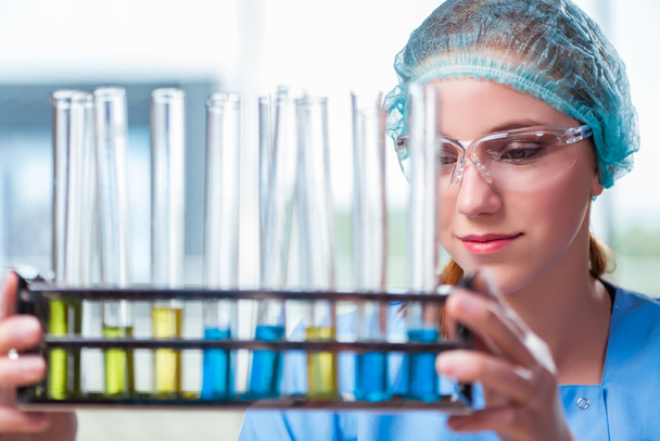Молодой студент, работающий с химическими растворами в лаборатории
 - Фото, изображение