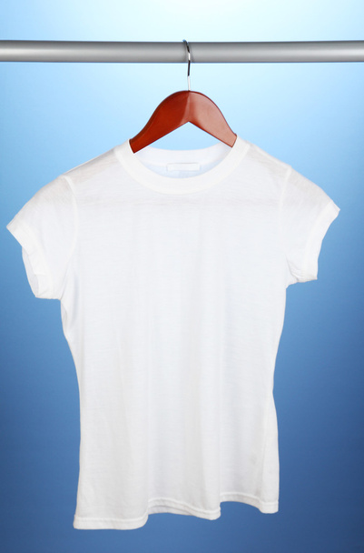 White t-shirt on hanger on blue background - Fotografie, Obrázek