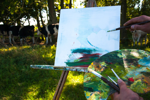 Hombre pintando un cuadro de vacas al aire libre
 - Foto, Imagen