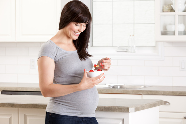 Pregnant Woman in Kitchen Eating Snack - Fotografie, Obrázek