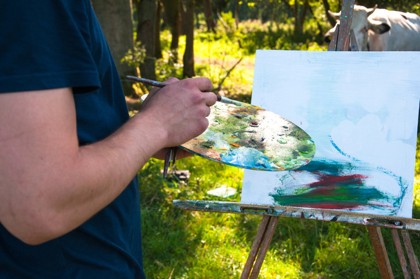 Людина малює картину на відкритому повітрі
 - Фото, зображення