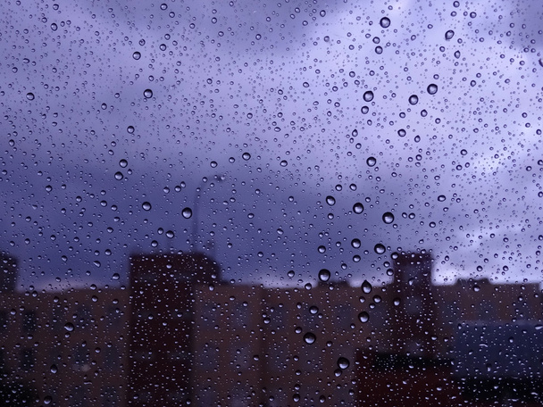 Autumn city through wet glass with rain drops stock image - Photo, Image