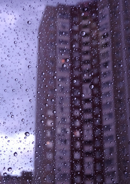 都市の天気予報を雨の窓に雨の滴  - 写真・画像