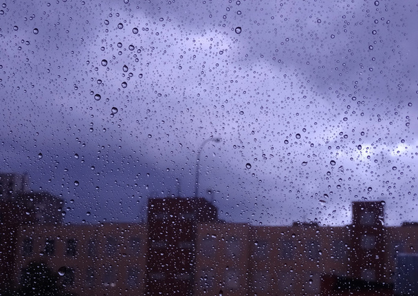 Look on rain at city through wet window glass stock photo  - Photo, Image