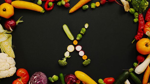 Gemüse aus Buchstabe x. Herbsternte erzeugt Buchstaben. Tomaten, Kohl, Paprika und anderes Gemüse auf schwarzem Hintergrund. - Foto, Bild