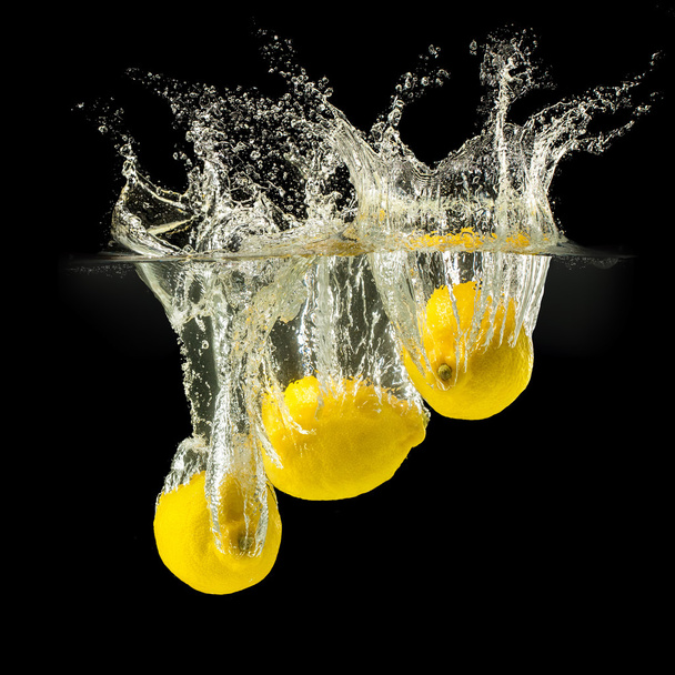 Group of fresh fruits falling in water with splash on black background - Foto, Bild
