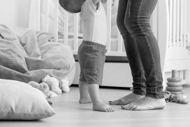 Musta ja valkoinen kuva 10 kuukauden ikäisestä vauvasta oppimassa kävelemään
 - Valokuva, kuva