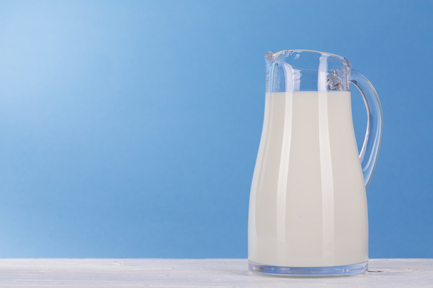 Jug of milk on blue background. - Photo, Image