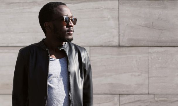 Fashion young african man wearing a sunglasses and black rock le - Fotó, kép