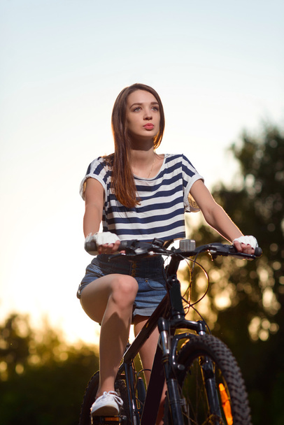 girl on a bicycle at sunset - Valokuva, kuva