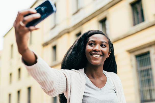 Kobieta trzyma smartfona biorąc selfie - Zdjęcie, obraz