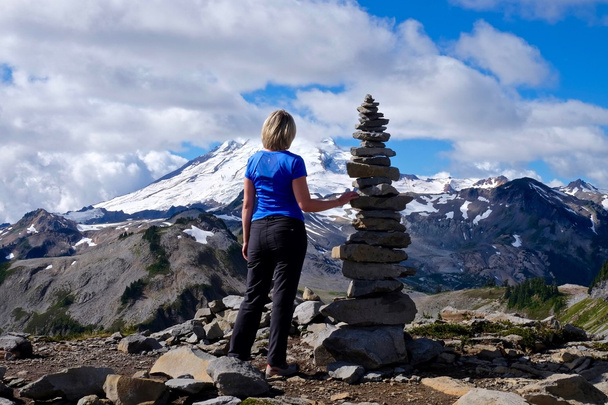 Женщина на вершине горы с каменным куэрном
.  - Фото, изображение