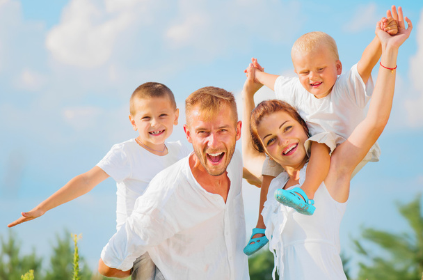 Счастливая молодая семья с двумя детьми
  - Фото, изображение