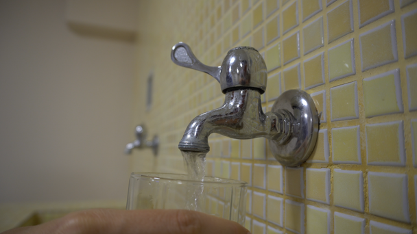 Ręka biorąc szklankę wody z kranu - Materiał filmowy, wideo
