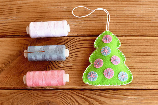 How to sew Christmas ornament. Step. Felt Christmas tree ornament, thread set, needle on a wooden background. Top view. Felt Christmas tree sewing diy for kids tutorial - Photo, Image