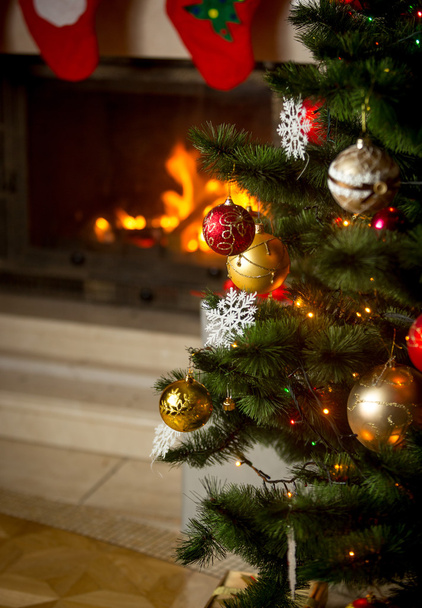 Background of decorated Christmas tree in front of burning firep - Photo, Image