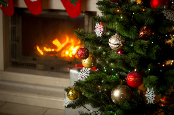 Şömine evinde yanan önünde dekore edilmiş Noel ağacı. - Fotoğraf, Görsel
