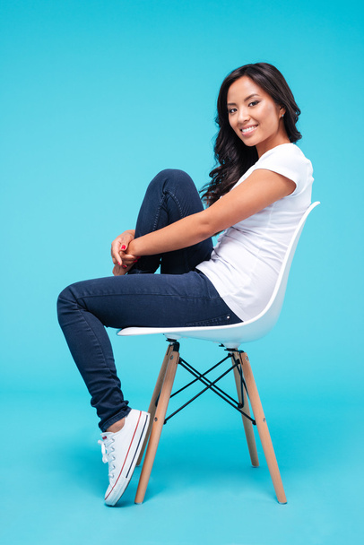 Smiling attractive asian woman sitting on the chair - Foto, Imagem