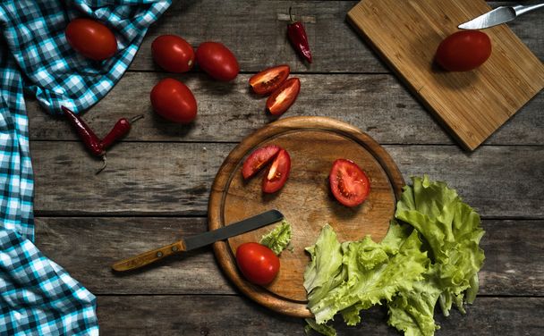 Fresh cherry tomatoes, peppers, lettuce on rustic wooden background. Top view - 写真・画像