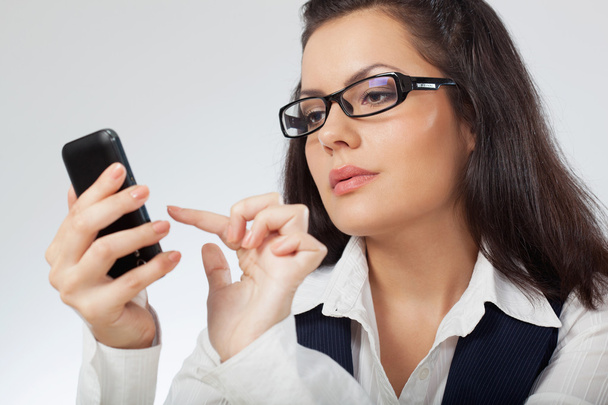 Businesswoman looking at mobile phone - Photo, Image