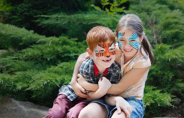 Niños felices, niño y niña con pintura facial en el parque
 - Foto, Imagen