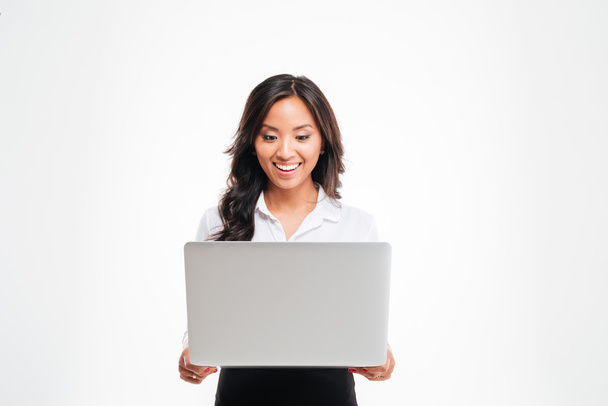 Happy young asian businesswoman standing with laptop - Foto, imagen