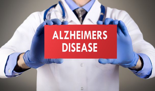 Doctor's hands in blue gloves shows the word alzheimers disease. Medical concept. - Foto, Imagen